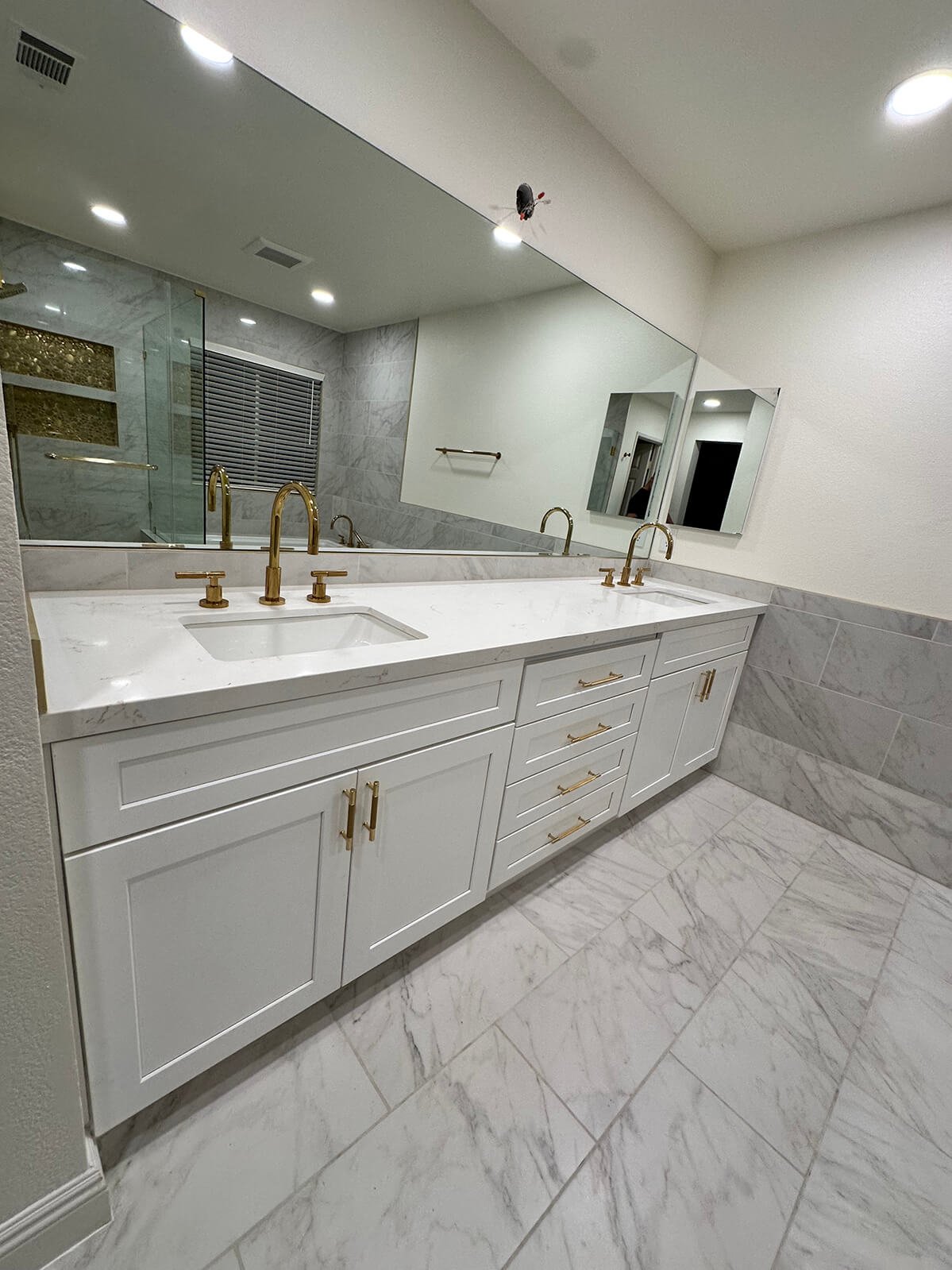 Marble primary bathroom with gold fixtures